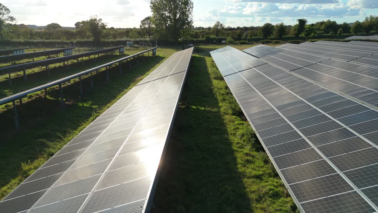 Smooth cinematic close aerial of solar panels harvesting evening light with warm tones and calm sky