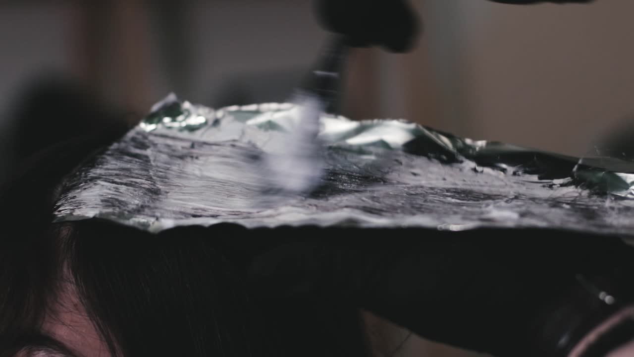 미용실에서 여성 고객의 머리를 염색하는 전문 미용사