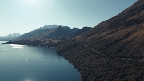 Cars-driving-down-mountainous-coastal-road-in-New-Zealand