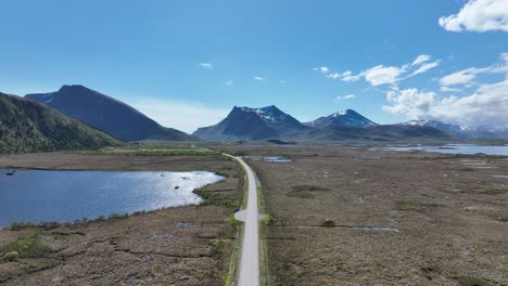 driving forward on gimsoy island road in lofoten, then turning into raising aerial revealing endless road and landscape