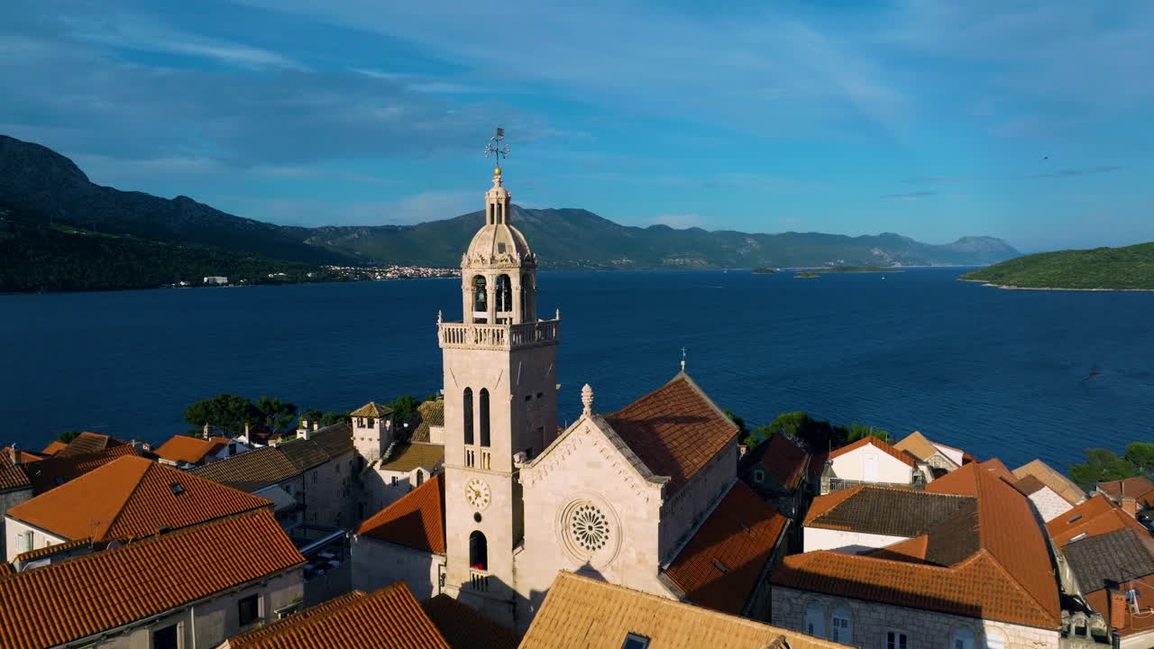 Saint Mark Church Bell Tower Near The Old Town of Korcula, Croatia. Aerial Pullback Shot
