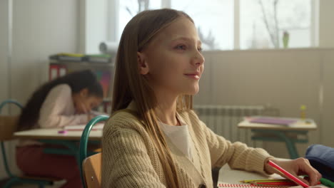 student studying at elementary school class. girl sitting at desk during lesson