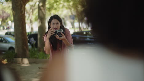 joven fotógrafa tomando fotos de personas en el parque