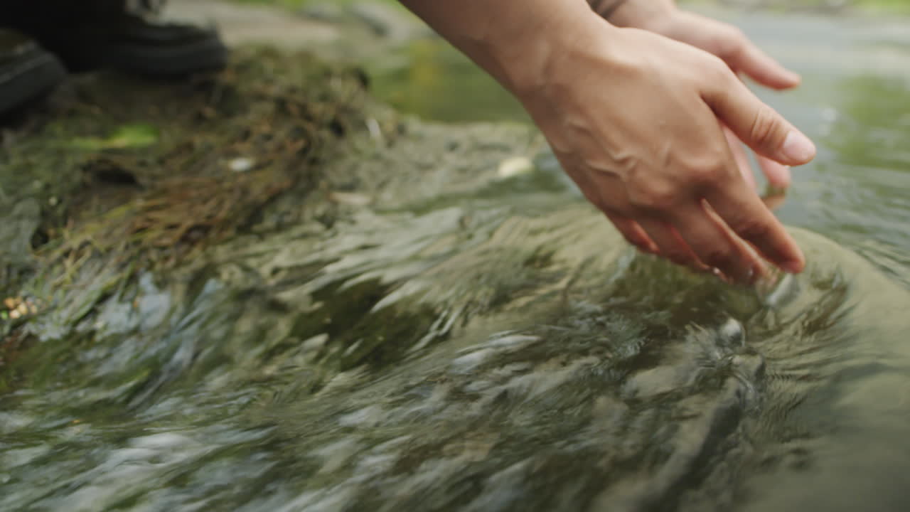 Female Tourist Holding Hands in River Water