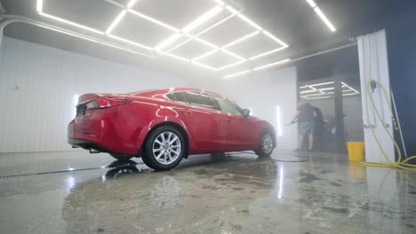lavado de automóviles limpieza con espuma y agua a alta presión. coche rojo