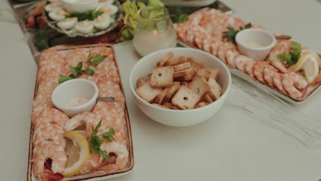 cold shrimp appetizers with lemon parsley and toast on white table