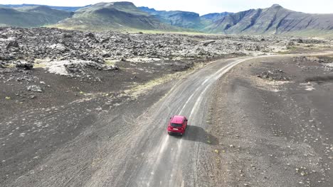 Sie-Folgen-Einem-Roten-Auto,-Das-Auf-Der-Unbefestigten-Straße-Entlang-Des-Lavafelds-Berserkjahraun-Auf-Der-Halbinsel-Snaefellsnes-In-Island-Fährt