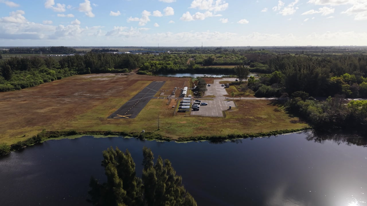 Drone flying over West Delray Park in Delray Beach Florida showing the runway of a model airplane club that operates in this multi use park.