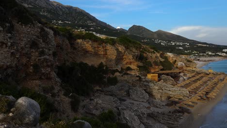 Panoramic-seaside-of-Albanian-tourist-villages-at-twilight,-quiet-beaches-washed-by-deep-blue-water-of-Ionian-sea