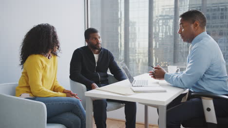 couple meeting with male financial advisor relationship counsellor in office