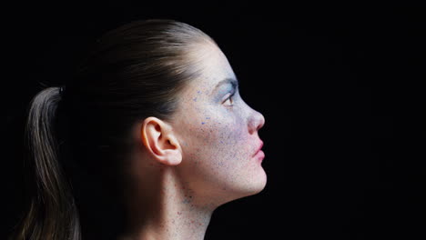 portrait beautiful woman wearing blue face paint makeup looking up exotic body art on attractive female performer creative expression light fading in dark background