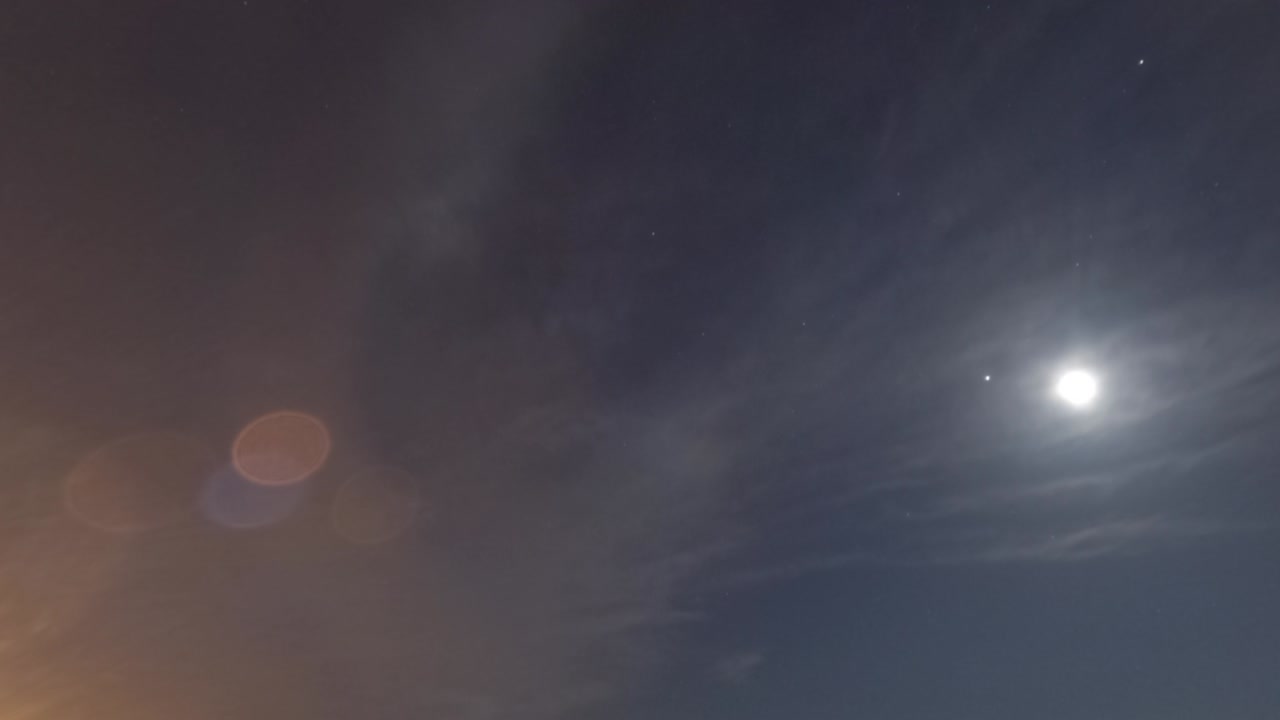 la luz de la luna naciente, el rayo de la estrella con la lente bokeh, el destello en el cielo nocturno oscuro, el lapso de tiempo.