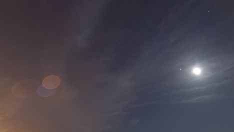 rising moon light ray n star with bokeh lens flare on dark night sky timelapse