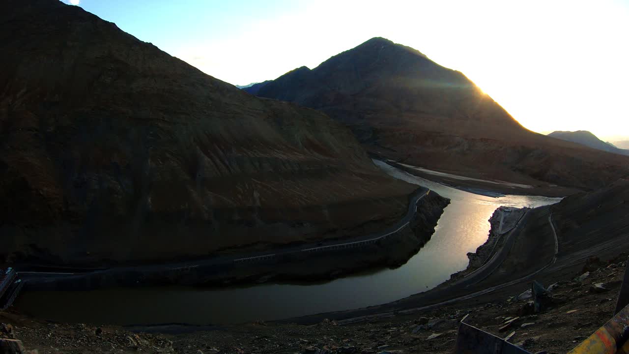 la confluencia y convergencia del río zanskar y el indo con montañas y sol al fondo