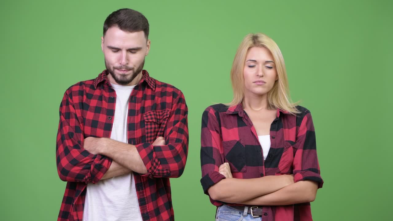 Young angry couple with eyes closed and arms crossed together