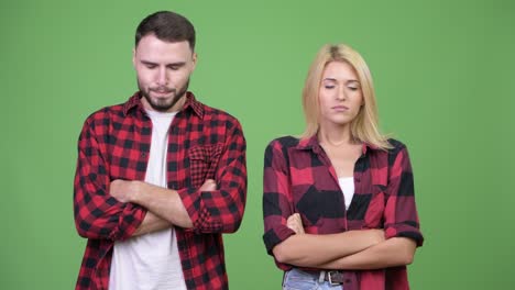 young angry couple with eyes closed and arms crossed together