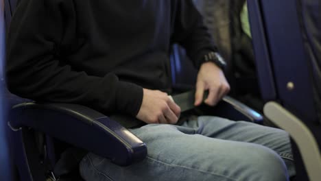 Close-up-view-of-man's-hands-fastening-himself-on-plane