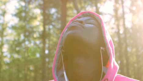 corredora femenina con los ojos cerrados de pie en el bosque 4k