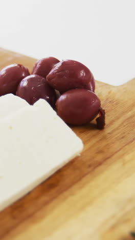 rebanadas de queso con aceitunas rojas y hierbas de romero