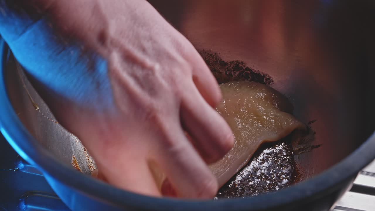 Hand Soaking Uncooked Chicken Breast In Stainless Bowl With Prepared Honey And Soy Sauce Marinade