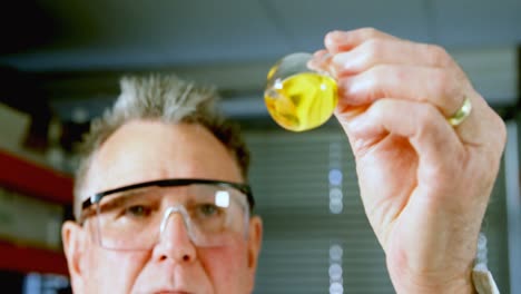 Male-scientist-looking-at-boiling-flask-in-laboratory-4k