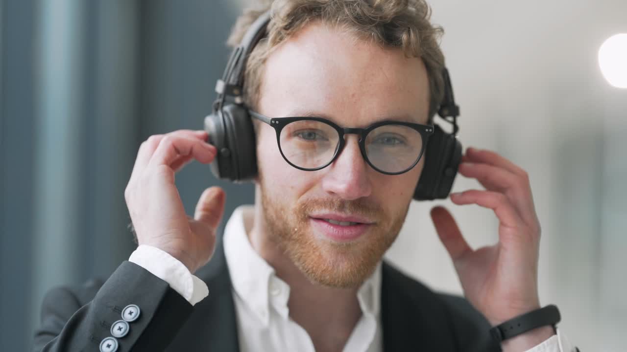 retrato de un joven elegante con auriculares y gafas