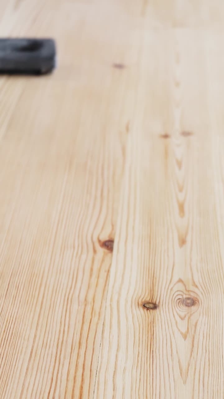 Primo piano di un aspirapolvere che rimuove la polvere da un pavimento in legno