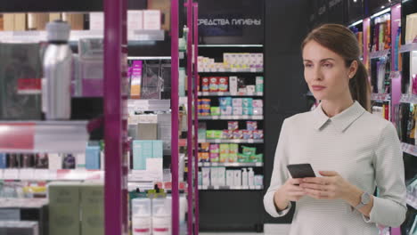 Woman Taking Photos Of Beauty Products In Cosmetics Store