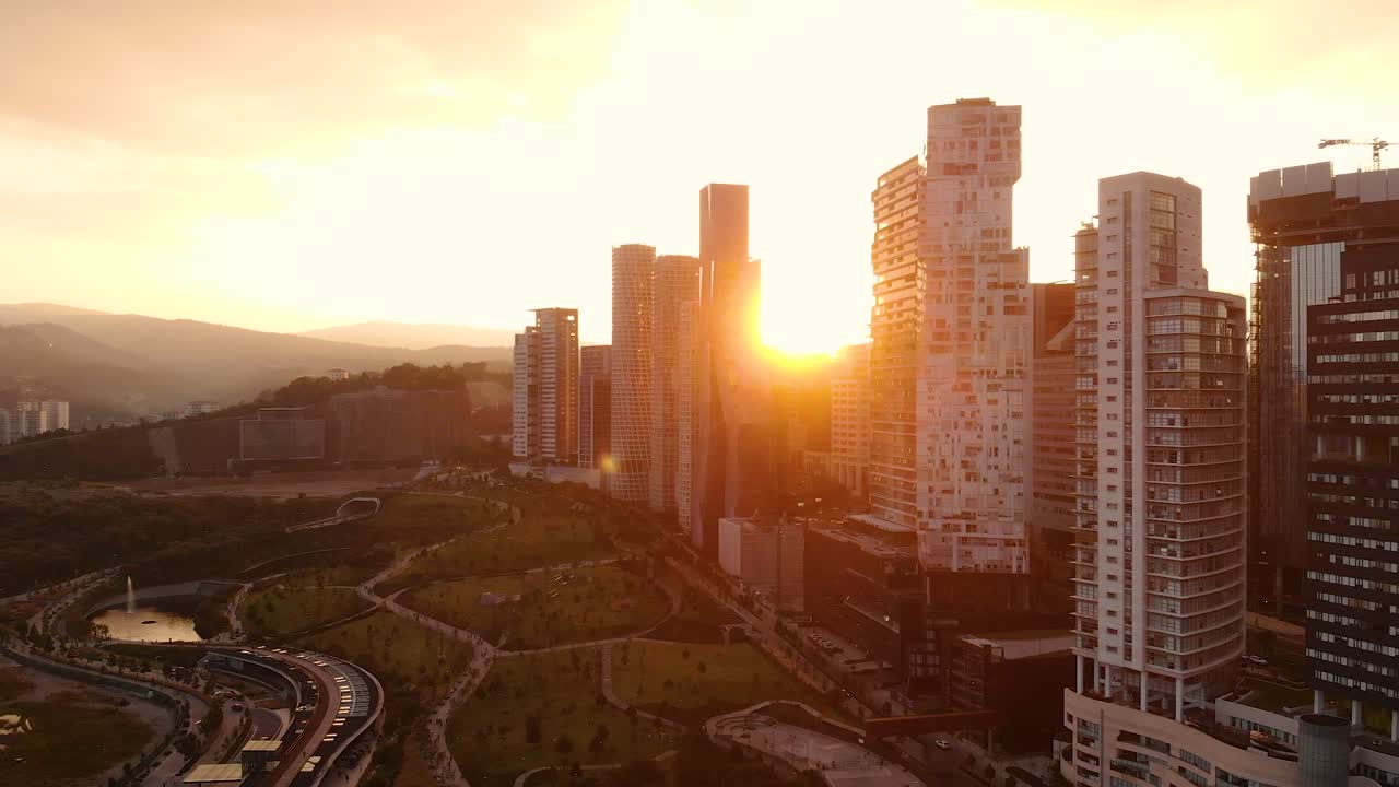Paisagem Urbana de Santa Fé com o Sol Brilhando Entre os Arranha-Céus do Centro no México em uma Tomada Aérea de Drone
