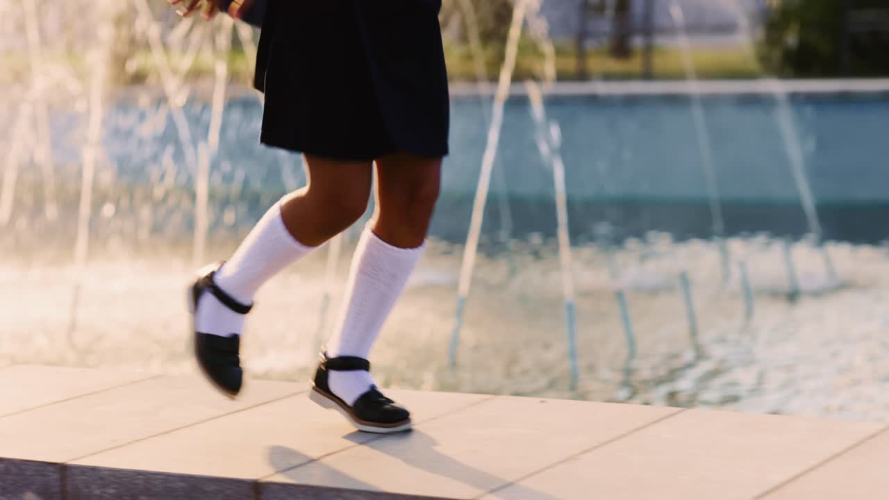 Girl jumping near a fountain