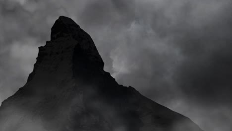 silueta de una colina rocosa con un fondo de tormenta y nubes negras