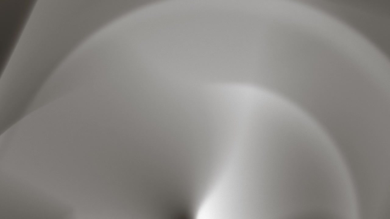 Un'animazione di nebbia grigia morbida e astratta che si muove in onde fluide e scorrevoli, formando ombre diffuse, pieghe luminose, sfumature sottili e una superficie nuvolosa in evoluzione
