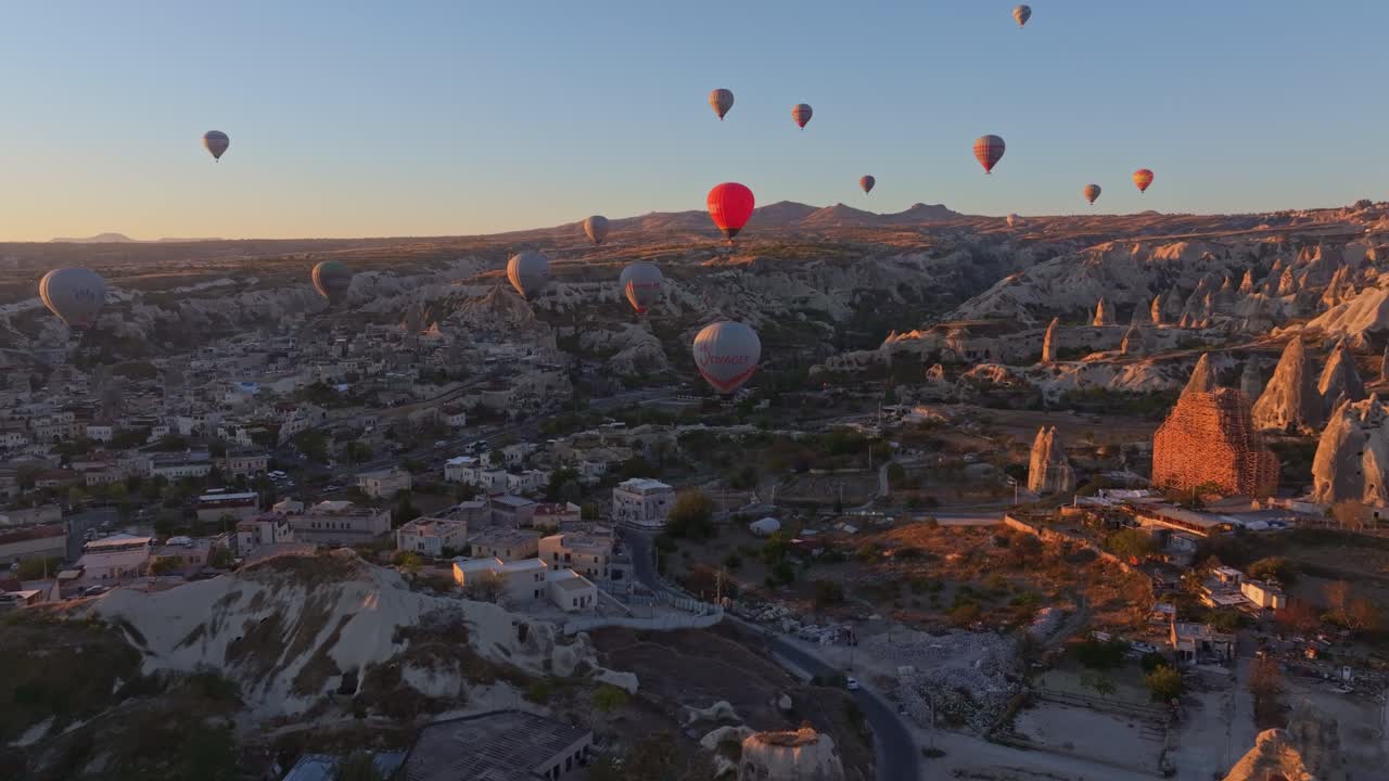 Vale da Capadócia iluminado pelo amanhecer com balões flutuando no alto