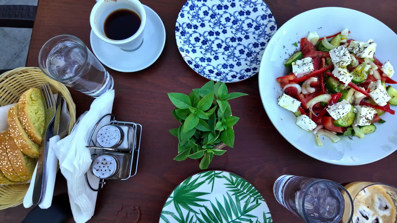 Table served with coffee, bread and delicious Greek salad with fresh vegetables and feta cheese in restaurant located in Sivas, Greece