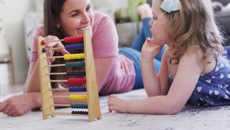 caucasian mother and daughter having fun using abacus