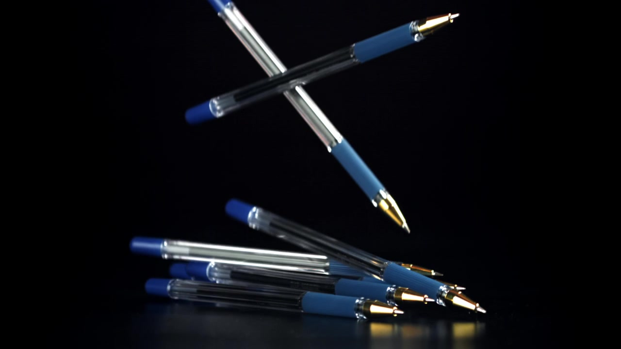 Blue Ballpoint Pens Falling and Landing on a Black Surface in Slow Motion