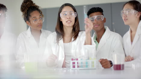five teenagers in lab coats are conducting an experiment in high school
