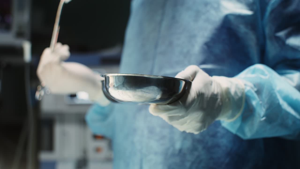 cirujano sosteniendo un cuenco quirúrgico