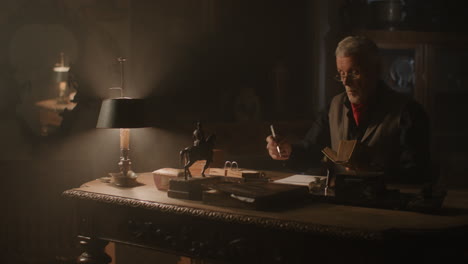 old passionate man evaluates a ceramic item in his office at night
