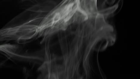 thin trickle silvery smoke slowly rising graceful twists upward. cigar smoke blowing from bottom to top. close-up, isolated on black background