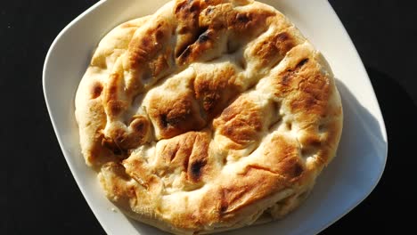 grilled round bread on a white plate