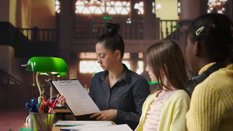 teacher helping students in a library setting