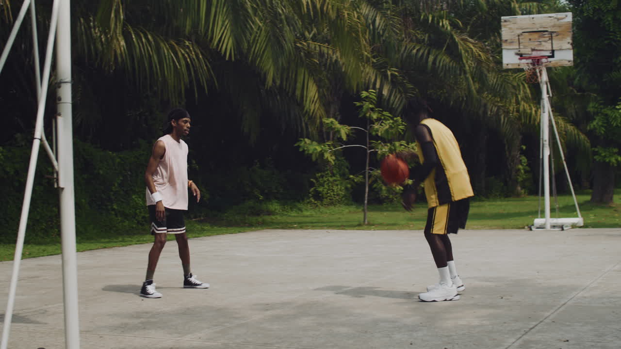 Sportsman Passing Ball to Another Player during Streetball Training