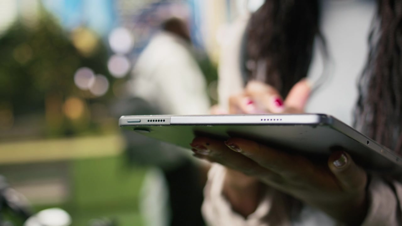 Close-up view of courier tapping digital tablet outdoors with hand
