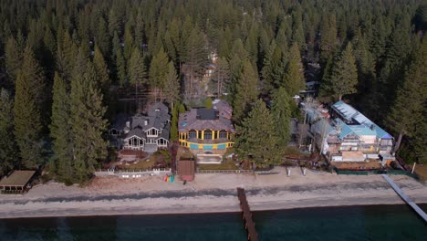 aerial view of lakefront mansions and villas by lake tahoe revealing pine forest and landscape, california usa