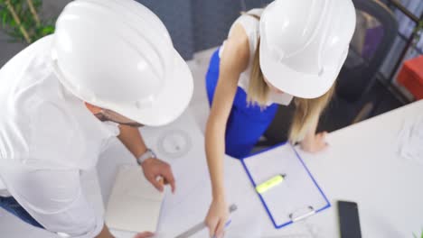 vista de arriba de los arquitectos discutiendo el dibujo del proyecto con documentos.