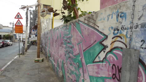 street graffiti in tel aviv, biker rides by on a delivery