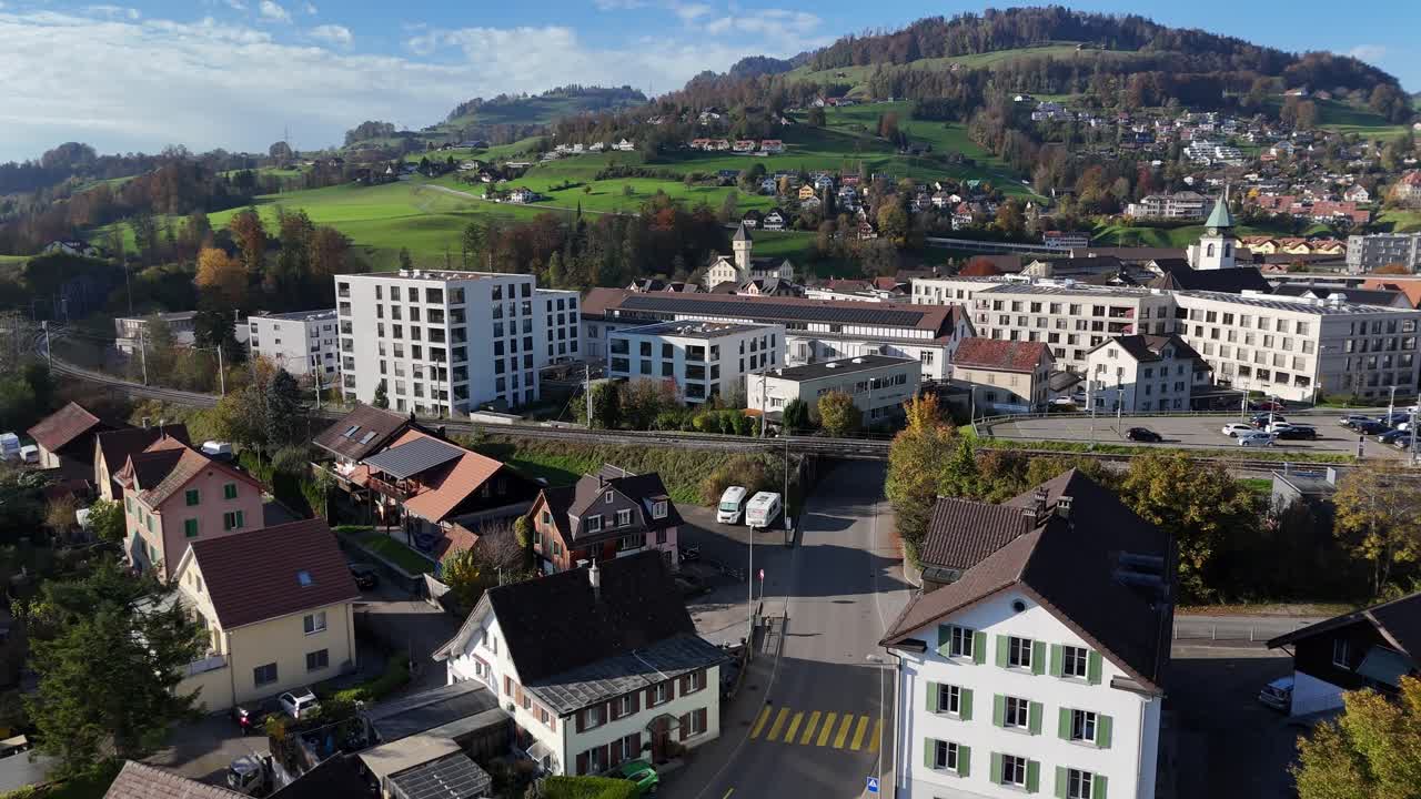 Small Swiss town of Wald in Zurich district with homes, green hills, and clear skies captured aerially