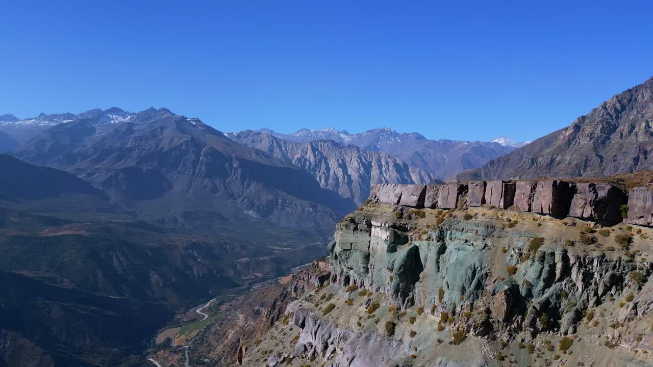 Drone orbit around eroded cliffs with mountain backdrop. Mirador de los Condores, Santiago, Chile