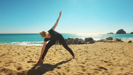 Frau-Praktiziert-Yoga-Asanas-An-Der-Küste-Des-Meeres.-Fittes-Mädchen,-Das-Beweglichkeitsübungen-Macht